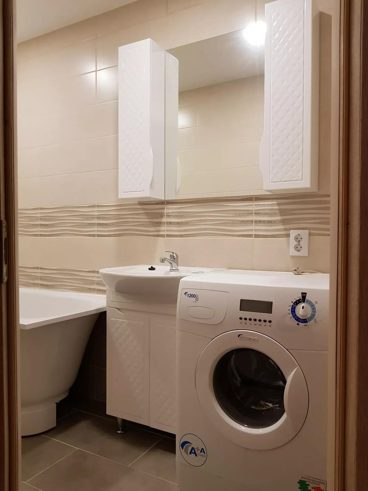 Зона раковины: тумба с раковиной, рядом стиральная машина, два высоких пенала и зеркало, розетка на стене.